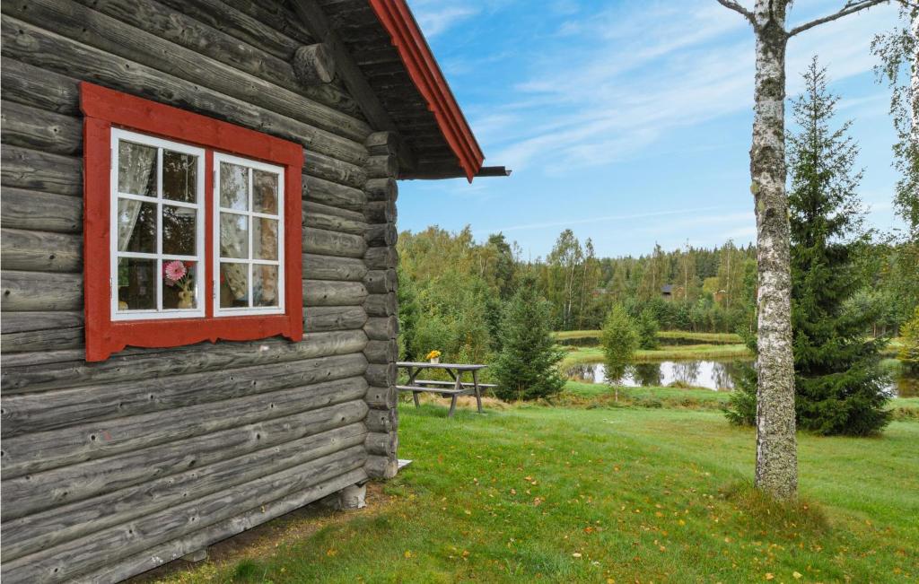 a log cabin with a window and a picnic table at 2 Bedroom Lovely Home In Sunne in Sunne