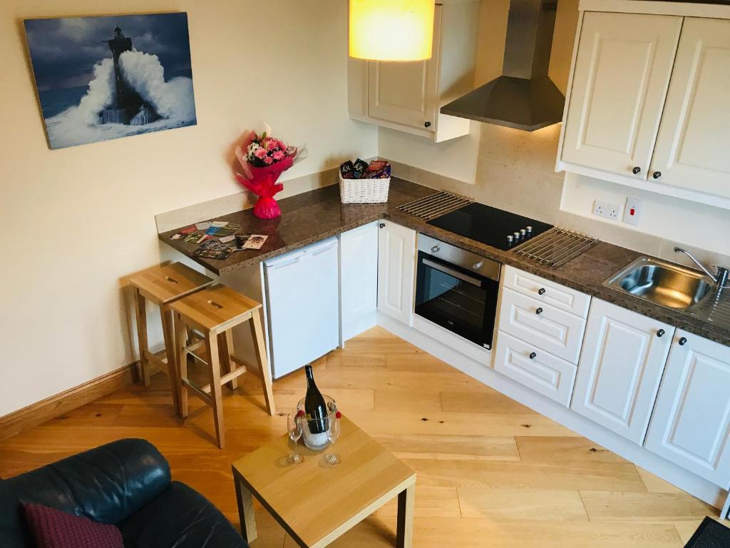 a small kitchen with white cabinets and a table at Oak Trees Corner stylish , relaxing , getaway in Wicklow