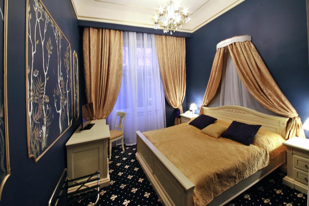 a blue bedroom with a bed with a canopy at Alisa Hotel in Karlovy Vary