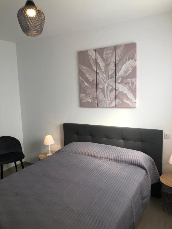 1 dormitorio con 1 cama y una pintura en la pared en L'Alivu, en Ajaccio
