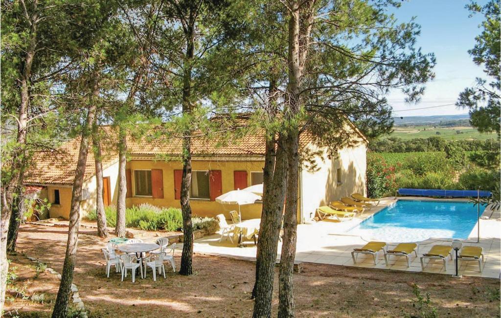 a house with a pool and a table and chairs at Pet Friendly Home In Cesseras With Outdoor Swimming Pool in Cesseras