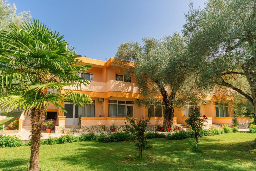 an orange house with trees in front of it at Apartments Aura in Utjeha