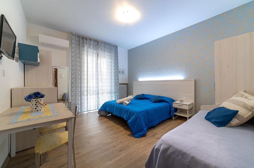 una camera con letto, tavolo e scrivania di B&B Villa Montreux a Rimini