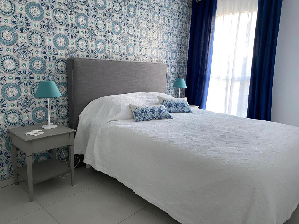 een slaapkamer met een groot bed met blauw en wit behang bij Spacieux appartement avec jardin dans résidence de grand standing avec piscine in Sanary-sur-Mer