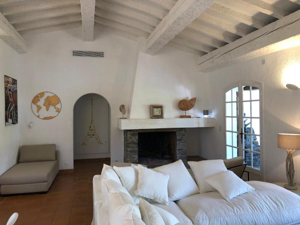 a living room with a white couch and a fireplace at Maison sous les Pins in Cavalaire-sur-Mer