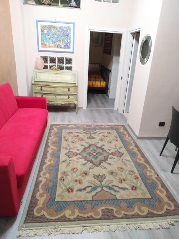 a living room with a red couch and a rug at Casa Pif in Frosinone
