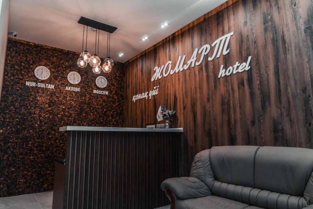 a waiting room with a chair in front of a wooden wall at ЖОМАРТ in Aktobe