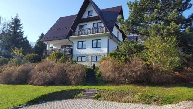 a large white house with a black roof at DOM KKK in Rabka