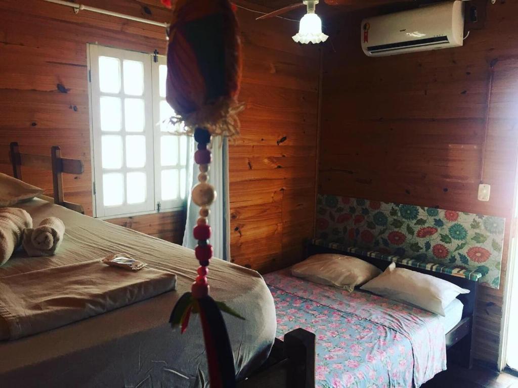 1 dormitorio con 2 camas en una cabaña de madera en Retiro espiritualista pousada casa de madeira, en Porto de Galinhas