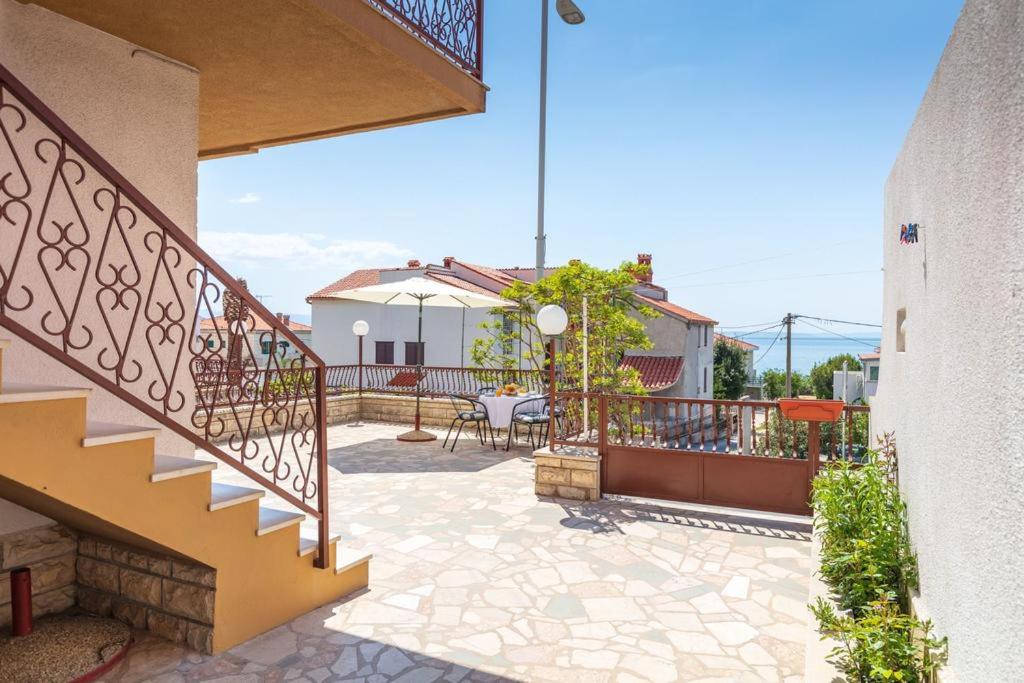 a patio with stairs and a table and chairs at Apartment Beky in Podstrana
