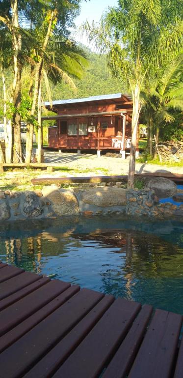 a house sitting next to a body of water at Ada Verde in Rio dos Cedros