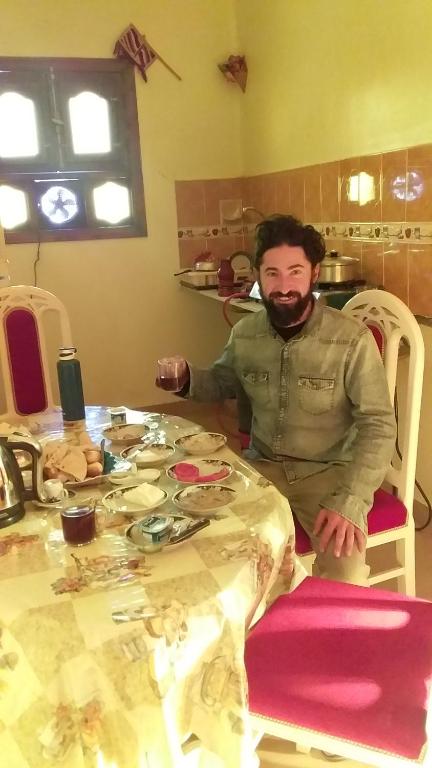 a man sitting at a table in a kitchen at Roma House in Aswan