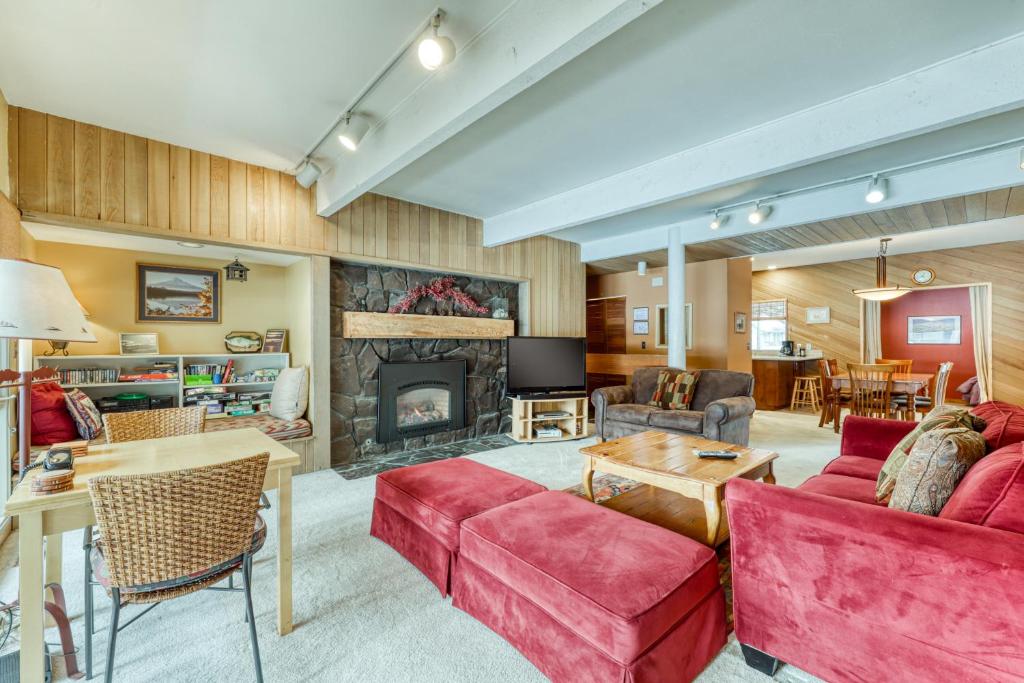 a living room with red furniture and a fireplace at Meadow House 15 | Discover Sunriver in Sunriver