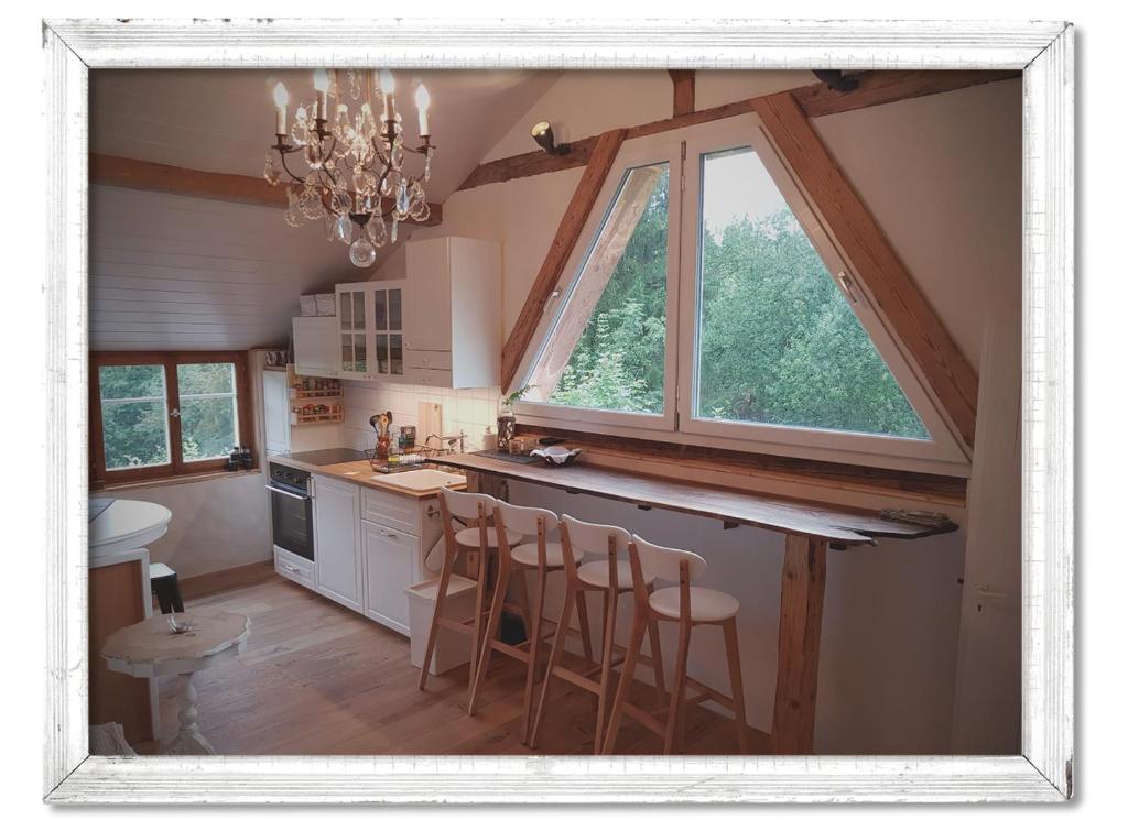 eine Küche mit einem Kronleuchter und einem großen Fenster in der Unterkunft Studio Chic Wildhaus in Wildhaus