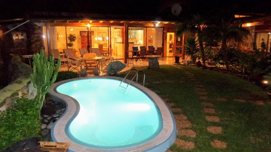 a swimming pool in the yard of a house at night at Bungalow 21 Tauro in La Playa de Tauro