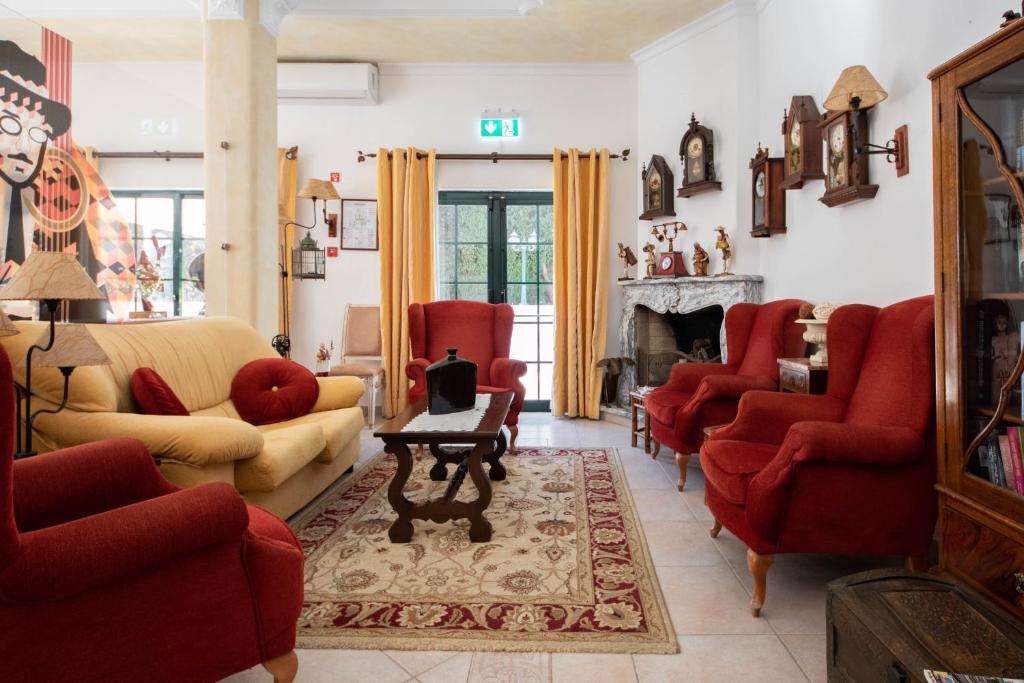 a living room with red chairs and a fireplace at Solar de Mos in Lagos