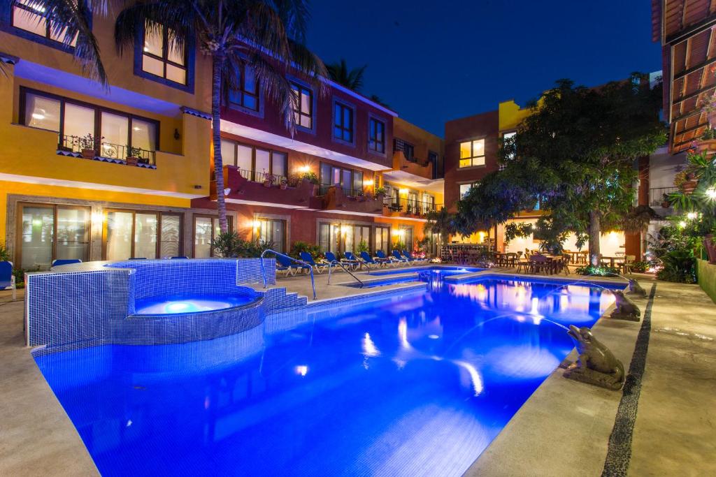 una piscina frente a un edificio por la noche en Casa Lotería -Pueblito Sayulita- Colorful, Family and Relax Experience with Private Parking and Pool en Sayulita