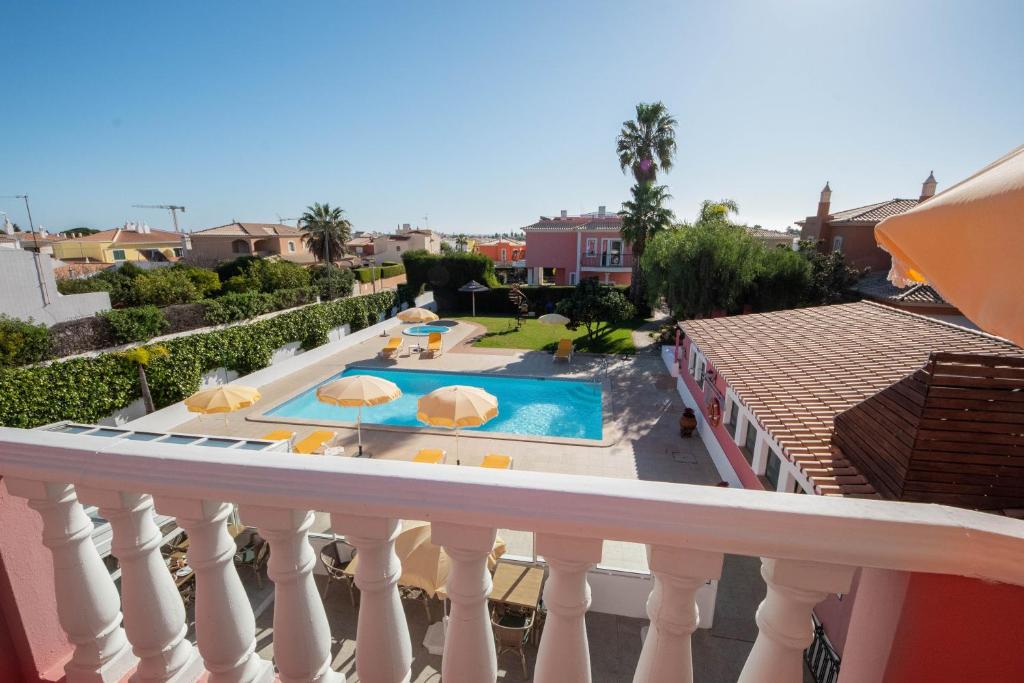 a balcony with a swimming pool with umbrellas at Solar de Mos in Lagos
