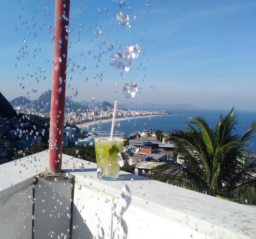 a drink on a ledge with a view of the ocean at Natural Do Rio Guesthouse in Rio de Janeiro