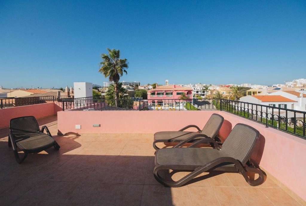 two chairs on a balcony with a view of a city at Solar de Mos in Lagos