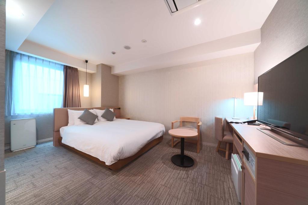 a hotel room with a bed and a television at Meitetsu Inn Hamamatsucho in Tokyo
