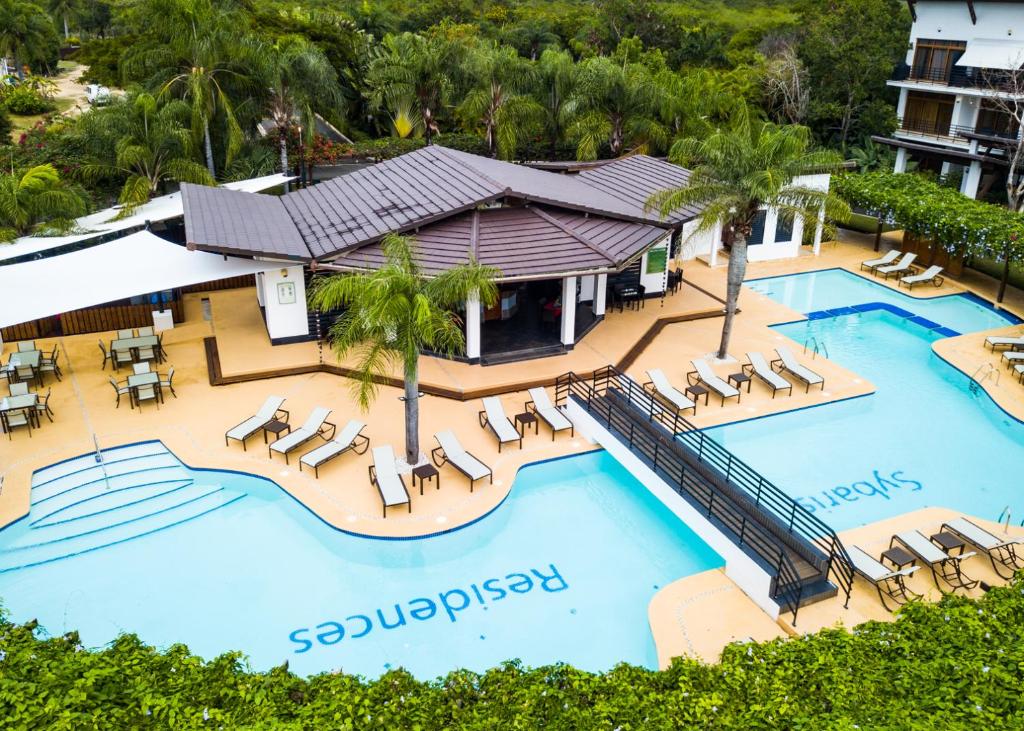 una vista aérea de una piscina del complejo con tumbonas en Sybaris Suites & Residences en Juan Dolio