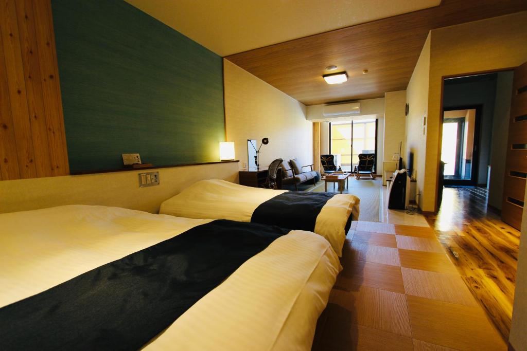 Habitación de hotel con 2 camas y sala de estar. en Kajitsu no Mori, en Ichinoseki