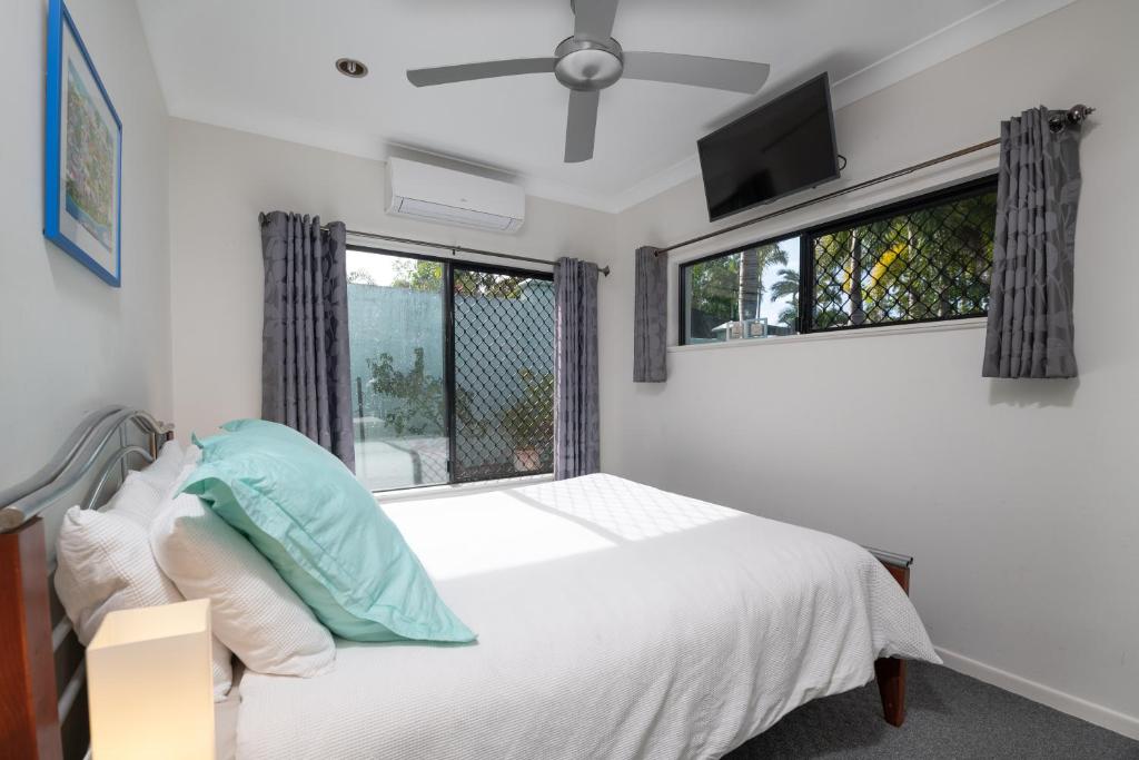 een slaapkamer met een wit bed en een raam bij Beach bliss, Netflix,Wifi in Kewarra Beach
