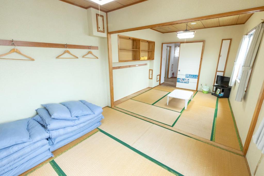 a living room with a blue couch and a table at kamekamehouse in Tokashiki
