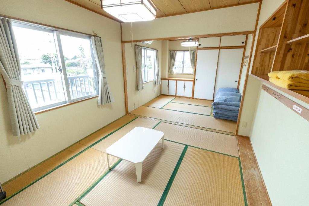a small room with a table and a bench in it at kamekamehouse in Tokashiki