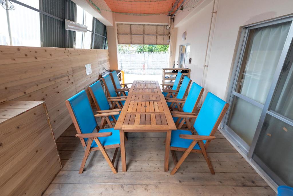 a wooden table and chairs on a patio at kamekamehouse in Tokashiki