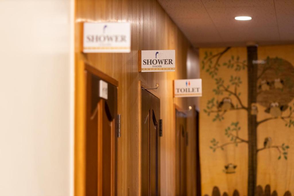 a row of wooden doors with signs on them at kamekamehouse in Tokashiki