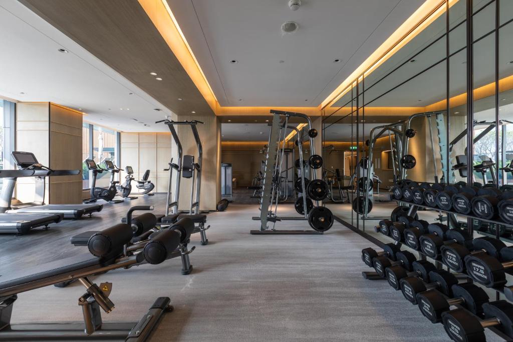 A bright, well-equipped fitness room with cardio and strength equipment.