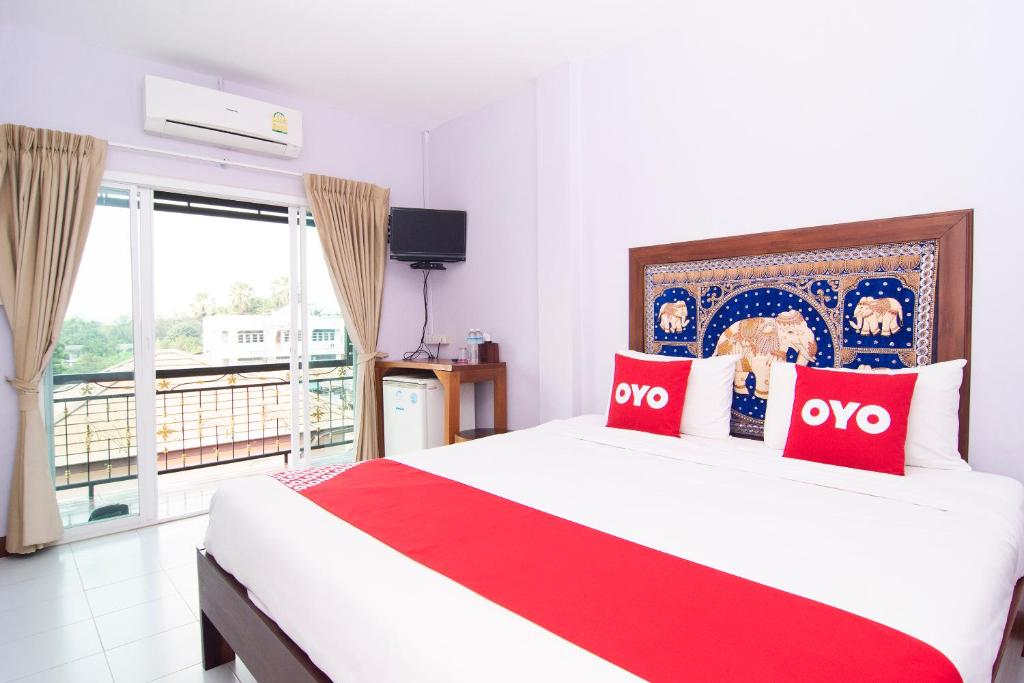 um quarto com uma cama grande e 2 almofadas vermelhas em OYO 587 Baan Taklom Chomtalay em Cha Am