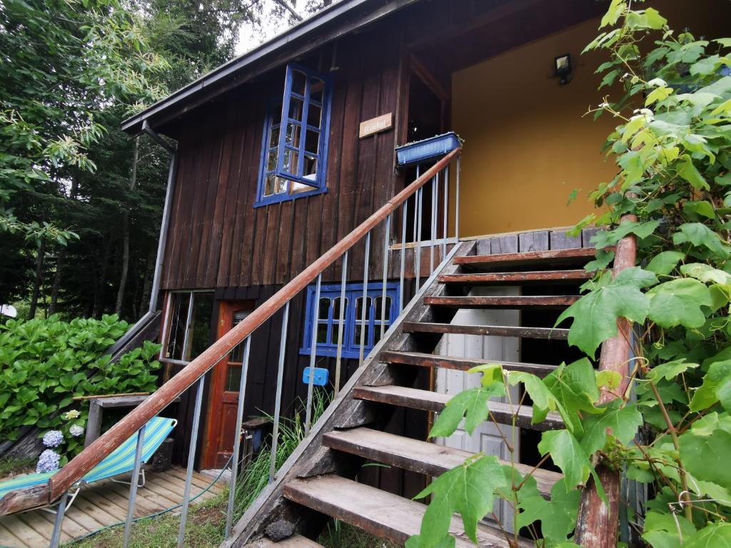 uma escada que leva a uma casa com uma janela em Cabaña Radal en Coñaripe cerca del lago Calafquén em Coñaripe