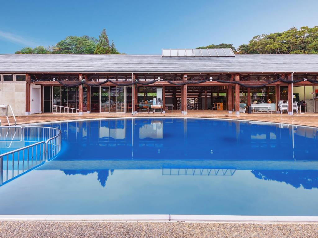 a large blue swimming pool in front of a building at Tabist Villa Daio Resort Ise-Shima in Shima