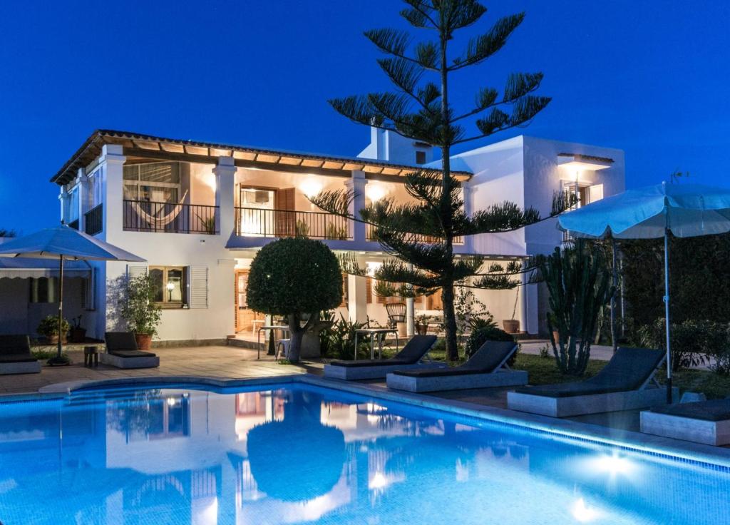 a villa with a swimming pool at night at Villa Wicker in Sant Jordi