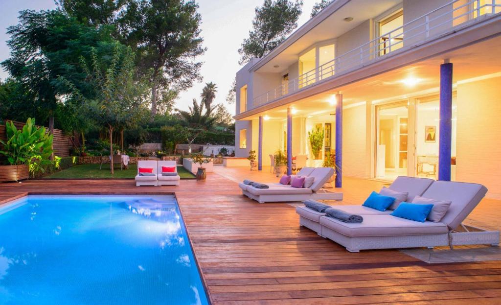 a patio with a pool and chairs and a house at Villa Melody in San Antonio Bay