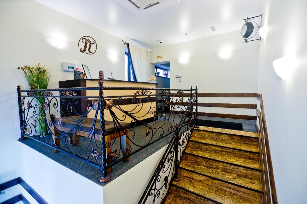 a staircase with a wrought iron railing and wooden stairs at Hotel Polina in Saratov