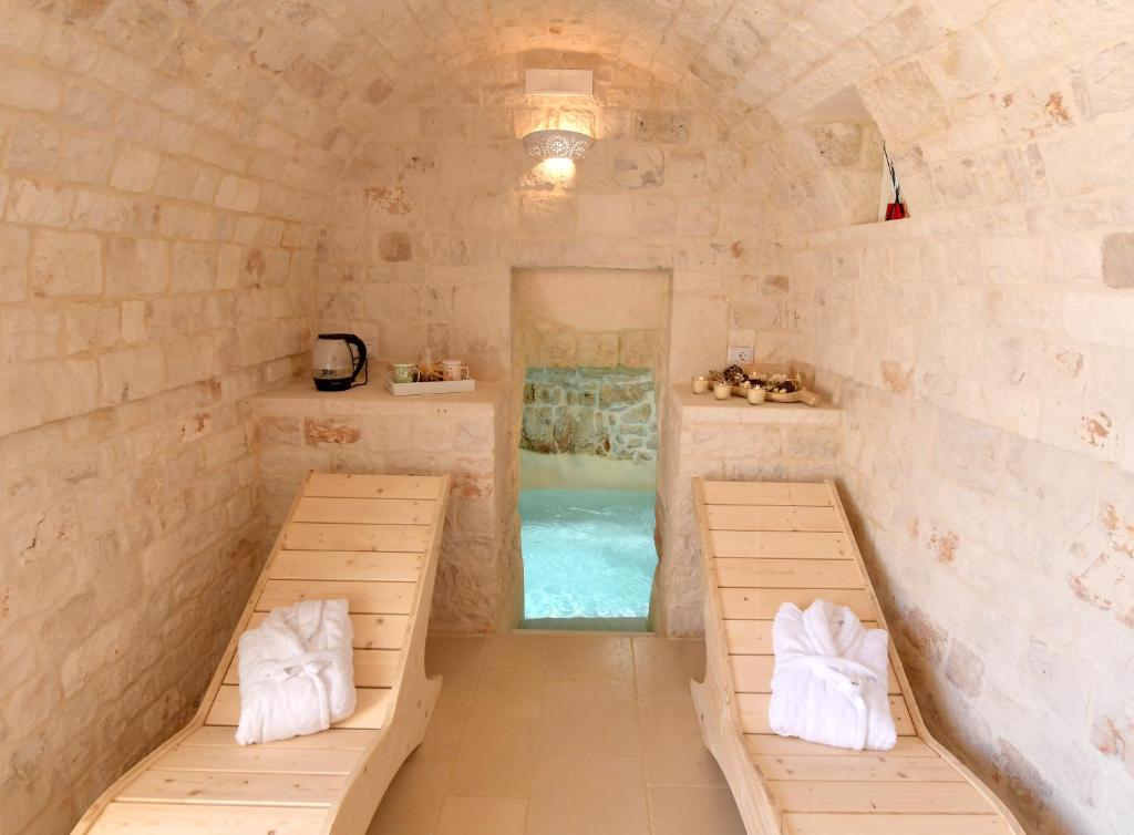 a room with two benches and a swimming pool at Trulli Santa Croce - Luxury Holiday - in Locorotondo