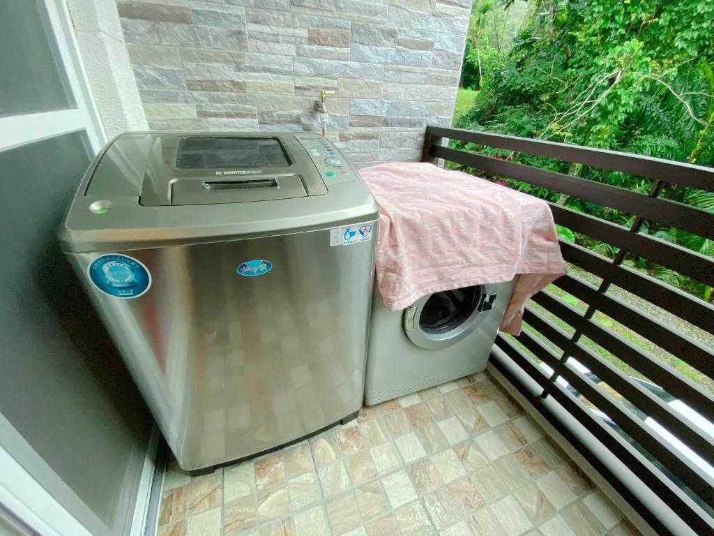 een wasmachine op een balkon met een tafel bij 賽斯村-魯柏館 in Fenglin