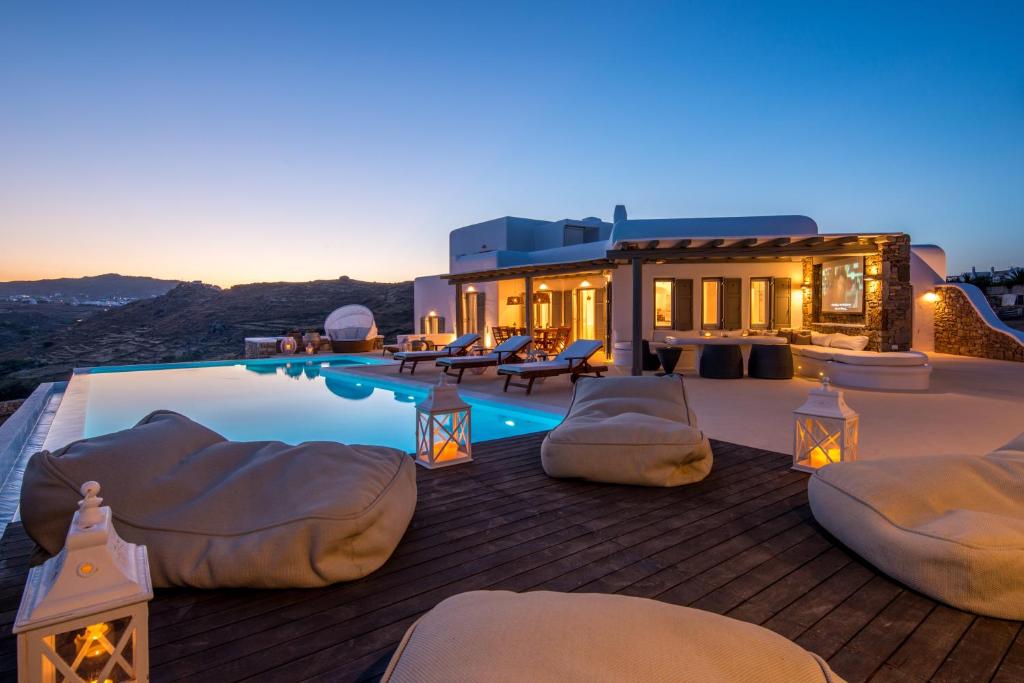 a luxury villa with a swimming pool at dusk at Margi Villas in Mikonos