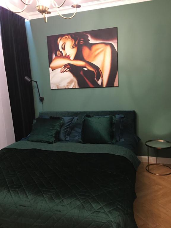 a bedroom with a bed with a painting on the wall at Luksusowy Apartament nad morzem in Gdańsk