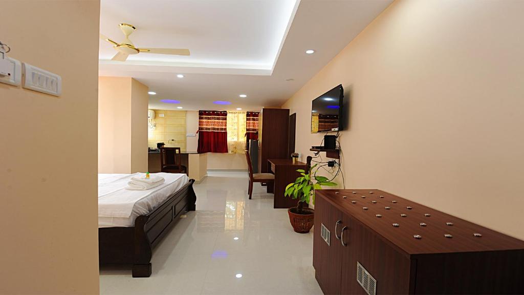 a bedroom with a bed and a desk in a room at FAMILY FRIENDLY STUDIO APARTMENT in Bengaluru