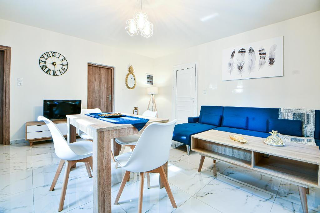 sala de estar con sofá azul y mesa en Koukounari Luxury Apartments, en Vathí