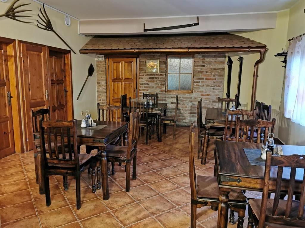 comedor con mesas y sillas de madera en Restaurace a penzion u Jessyho, en Perná