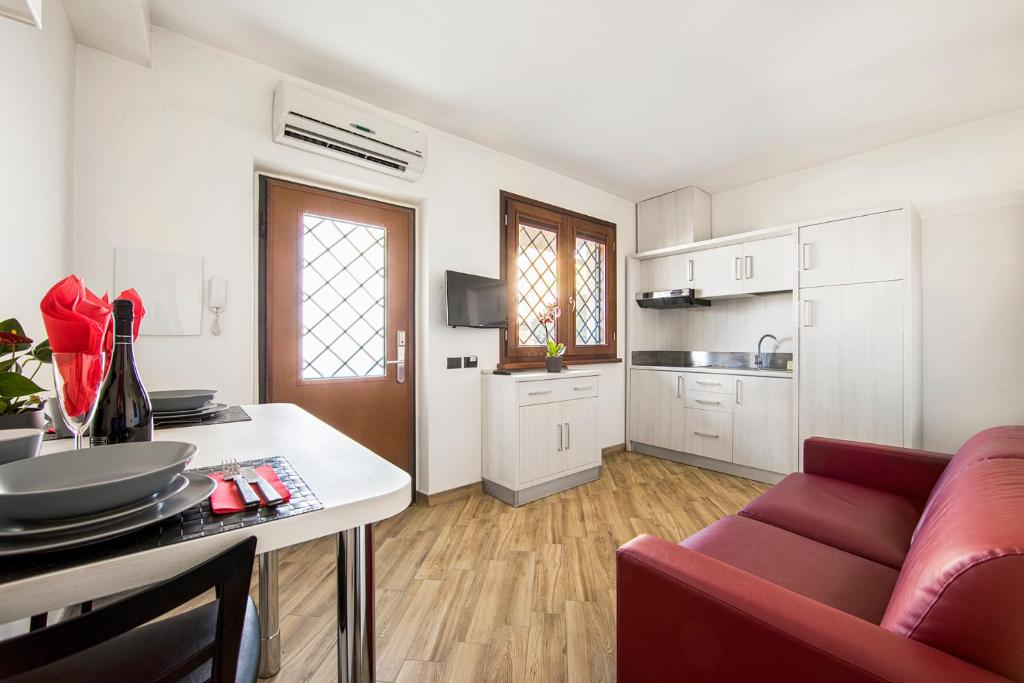 a kitchen and living room with a red couch at Borgo Aureo in Rome
