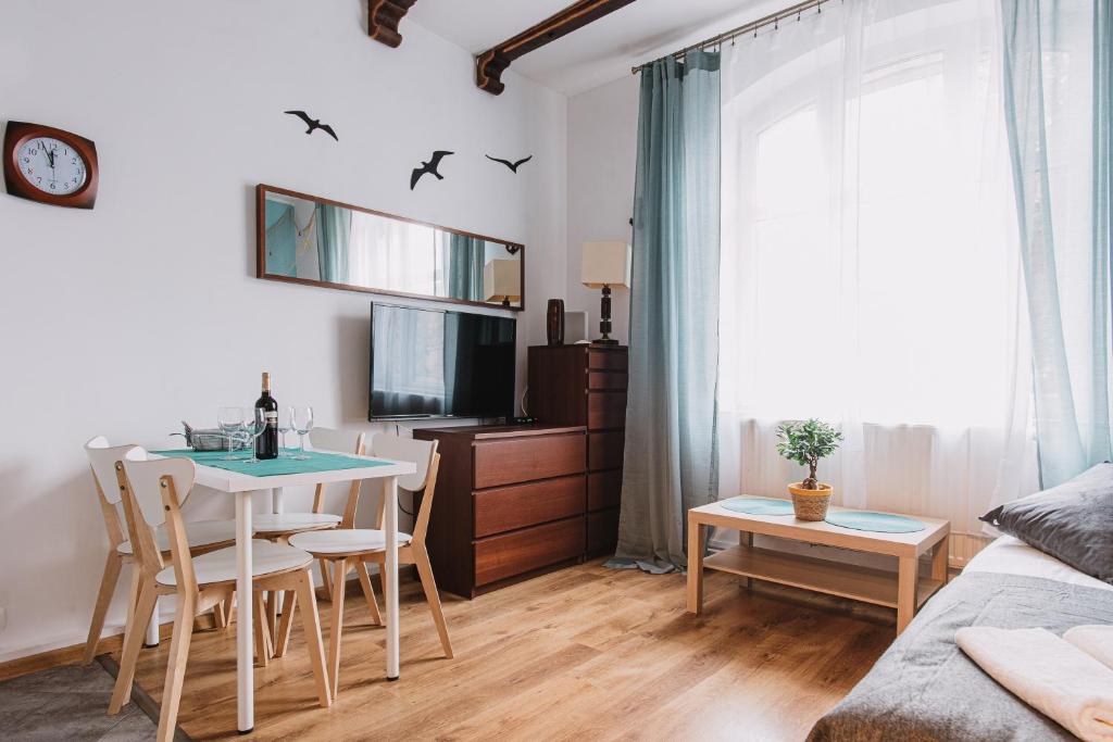 salon ze stołem, krzesłami i telewizorem w obiekcie Sopot Host Molo w mieście Sopot
