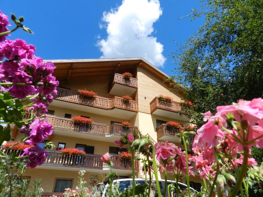 a building with flower boxes on its balconies at Cimon Dolomites Hotel in Predazzo