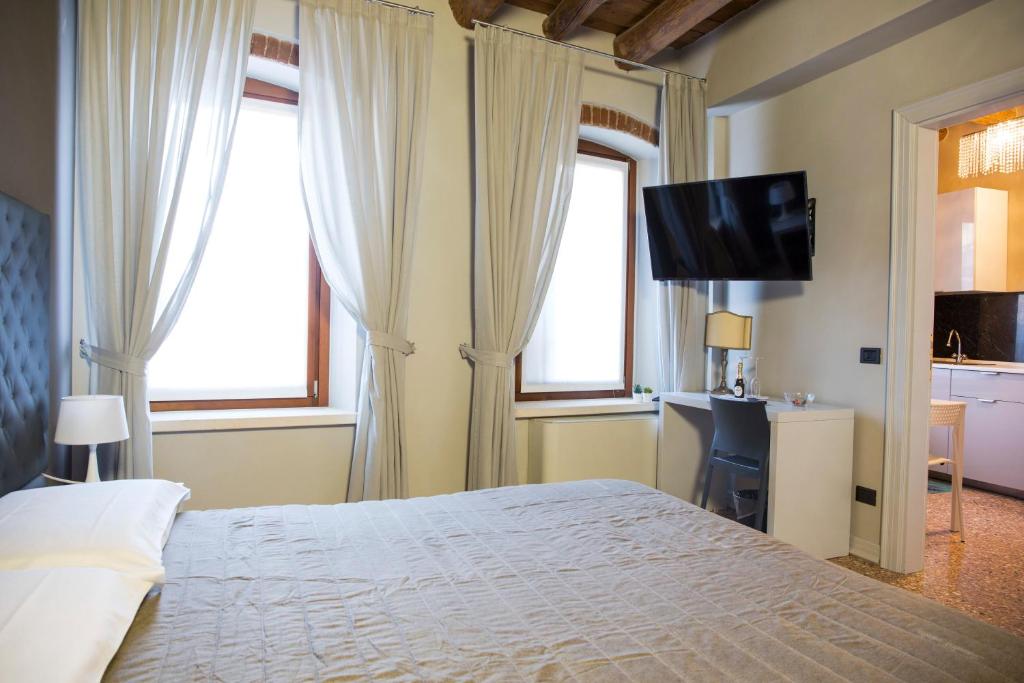 sypialnia z łóżkiem, biurkiem i telewizorem w obiekcie Torre Soave - Locazione Turistica w mieście Soave